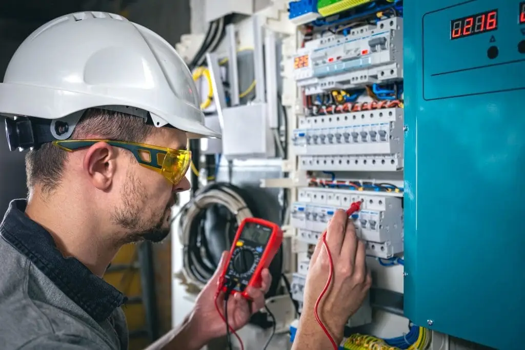 electrical technician working in a switchboard with fuses.